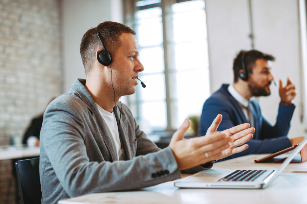 Man customer service talking on the headset with client and smiling