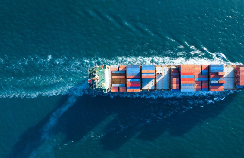 Aerial top view of cargo ship carrying container and running for export  goods  from  cargo yard port to custom ocean concept technology transportation , customs clearance.