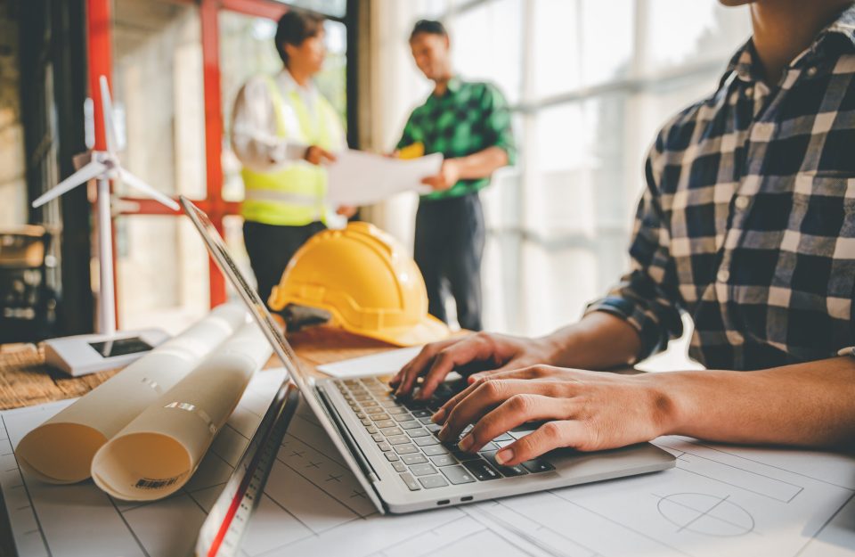 Engineers work as a team with blueprints for architectural plans. Engineer sketching construction project concept with architect equipment Architects talking at table Teamwork and construction concept