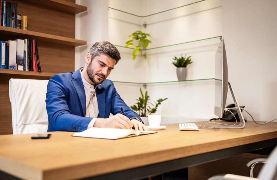 Experienced financial director working in his office and making calculations.